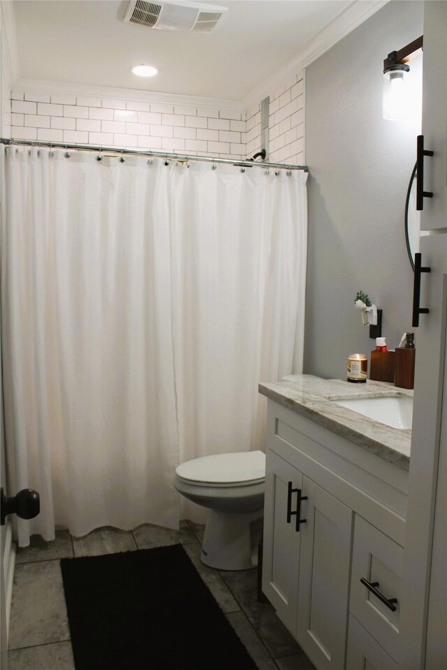 bathroom with ornamental molding, tile patterned flooring, vanity, toilet, and walk in shower