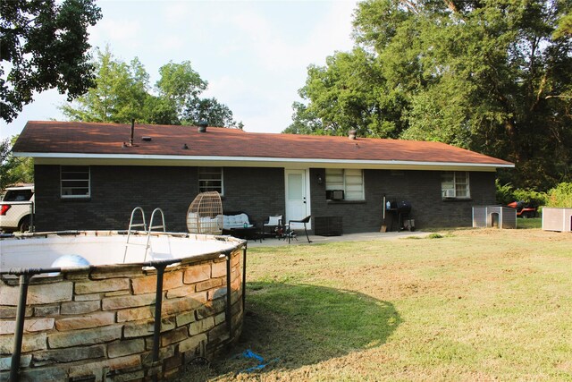 rear view of property with a patio and a yard