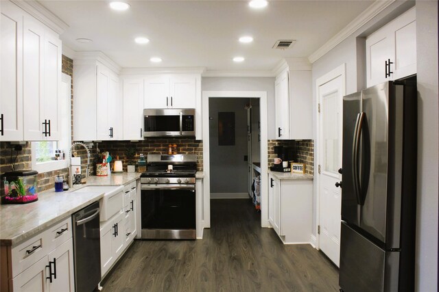 kitchen with white cabinets, dark hardwood / wood-style flooring, backsplash, and appliances with stainless steel finishes