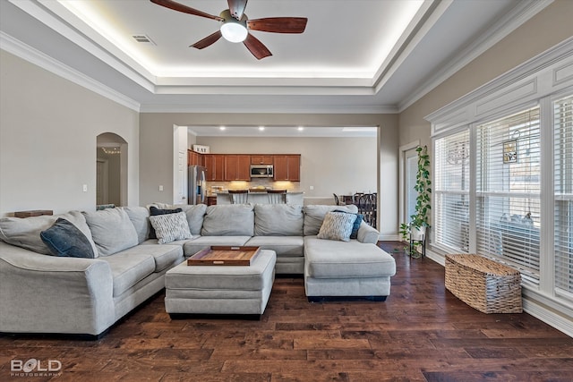 living room with a tray ceiling, ceiling fan, hardwood / wood-style floors, and crown molding