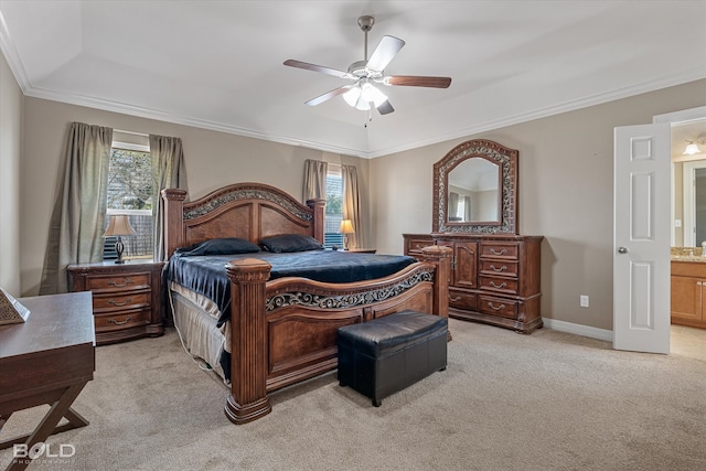 bedroom with ceiling fan, light colored carpet, multiple windows, and ensuite bath