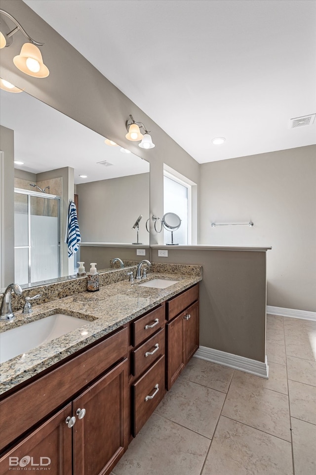 bathroom featuring tile patterned flooring, walk in shower, and vanity