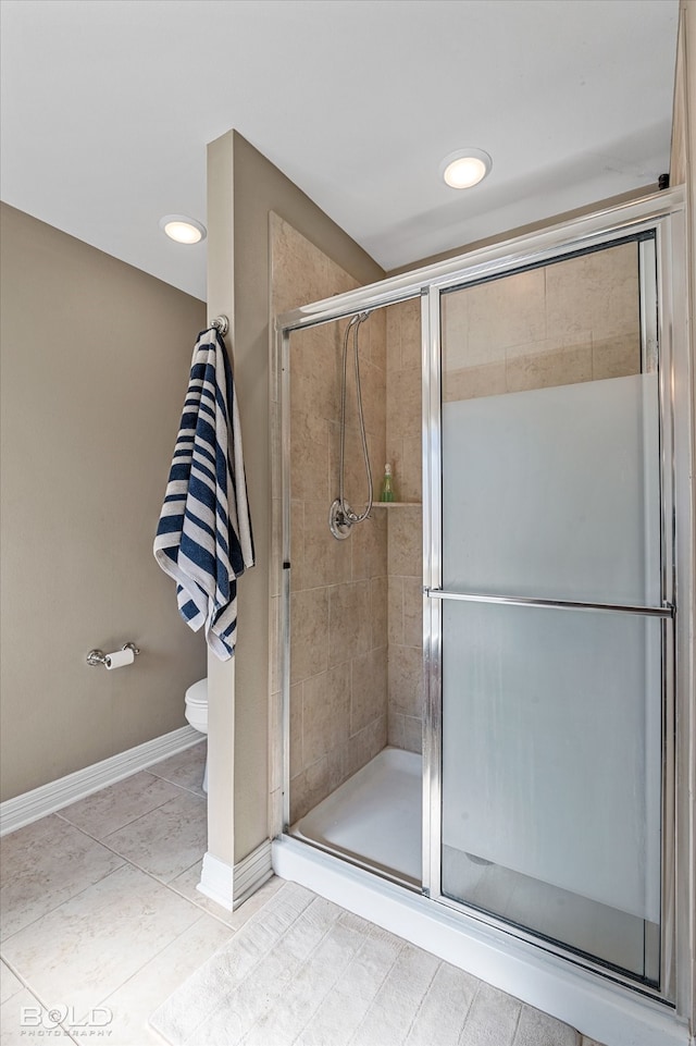 bathroom with toilet, walk in shower, and tile patterned floors