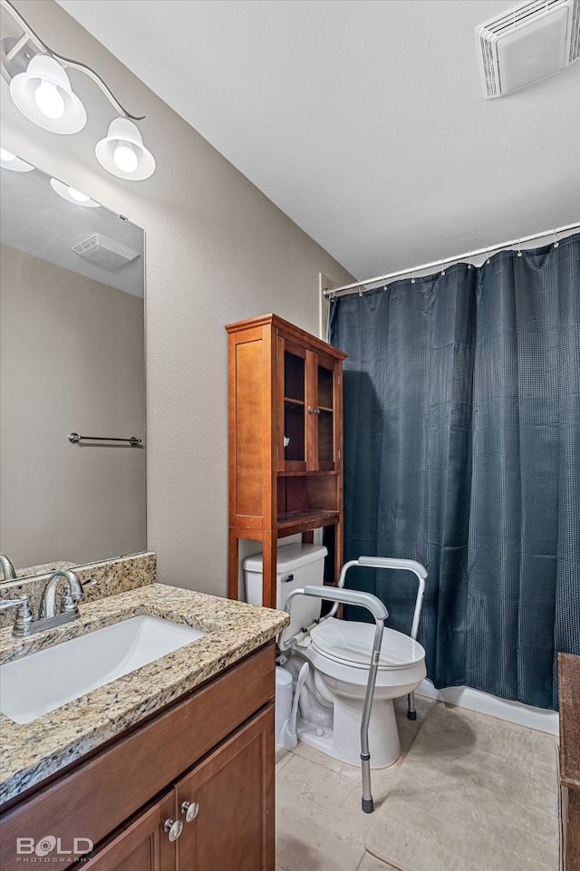 bathroom with tile patterned floors, toilet, vanity, and curtained shower