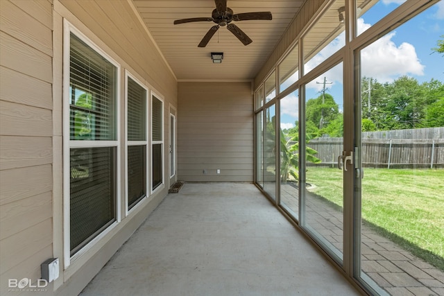 unfurnished sunroom with ceiling fan