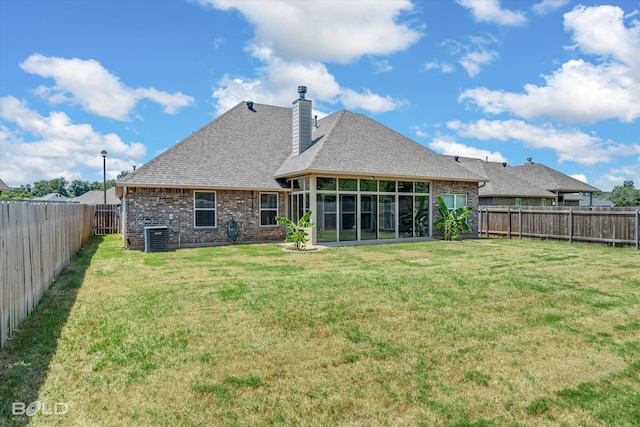 rear view of property featuring a yard and central AC