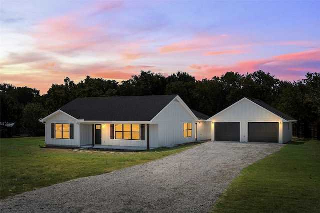 modern farmhouse featuring a garage and a lawn