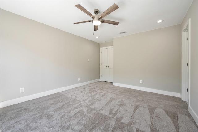 spare room featuring ceiling fan and light carpet