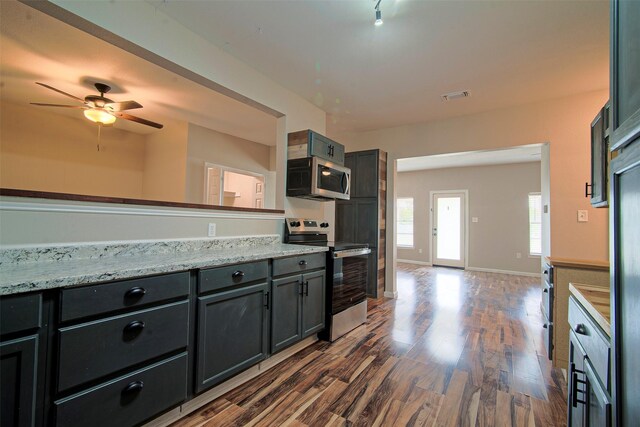 kitchen with stainless steel appliances, ceiling fan, dark hardwood / wood-style flooring, and light stone countertops