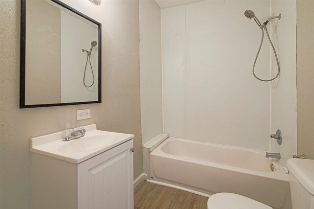 full bathroom featuring hardwood / wood-style flooring, bathtub / shower combination, vanity, and toilet