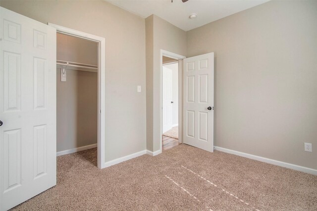 unfurnished bedroom with light carpet and a closet