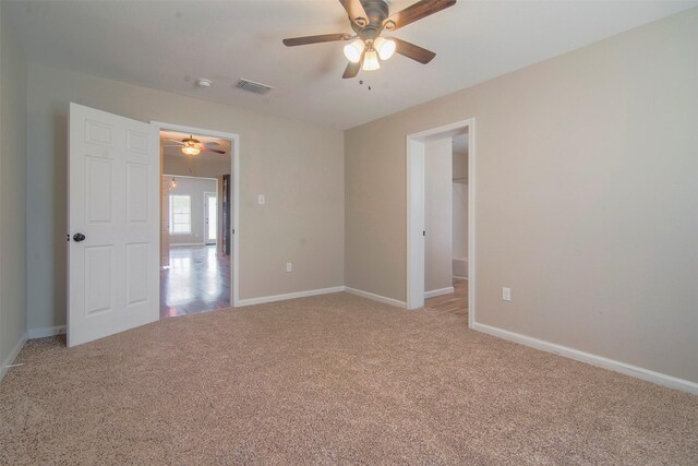 carpeted spare room featuring ceiling fan