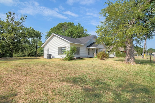 view of side of property featuring central air condition unit and a yard