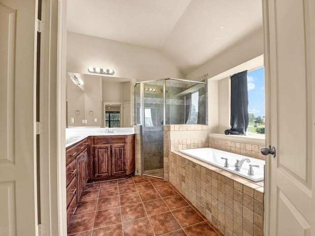 full bathroom with lofted ceiling, a shower stall, vanity, a bath, and tile patterned floors