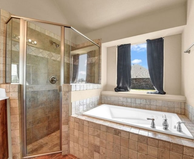 bathroom featuring vaulted ceiling, a shower stall, and a bath