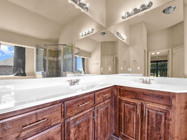 bathroom featuring a shower with door and vanity