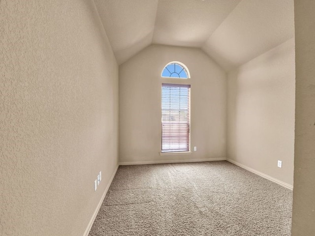 unfurnished room with vaulted ceiling and carpet floors