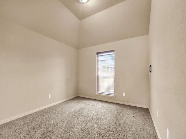 unfurnished room featuring carpet floors, baseboards, and vaulted ceiling