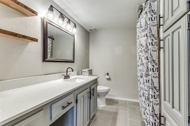 bathroom featuring tile patterned flooring, toilet, and vanity