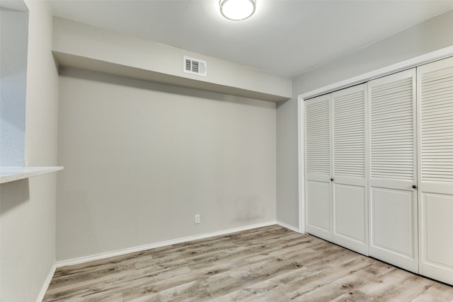 unfurnished bedroom featuring a closet and light wood-type flooring