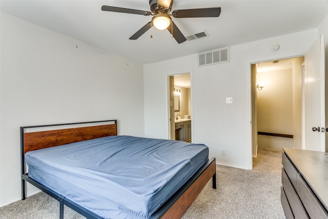 bedroom with ceiling fan, ensuite bathroom, and light carpet