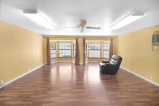 unfurnished room with ceiling fan, hardwood / wood-style flooring, a textured ceiling, and an AC wall unit