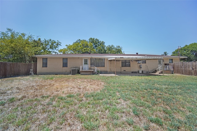 rear view of property with a lawn and central AC