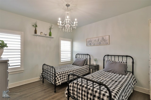 bedroom featuring an inviting chandelier, wood finished floors, and baseboards