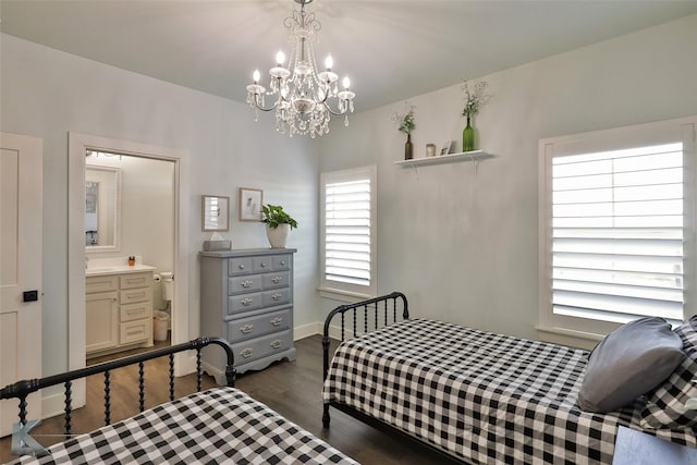 bedroom featuring ensuite bath, a chandelier, and dark wood-type flooring