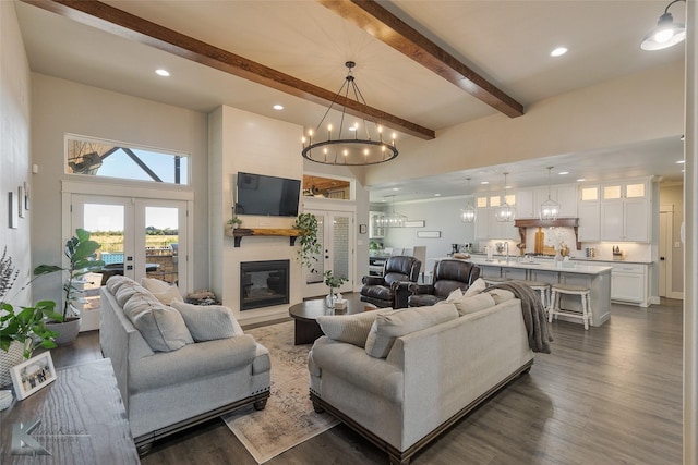 living room featuring recessed lighting, a large fireplace, dark wood-style flooring, french doors, and beamed ceiling