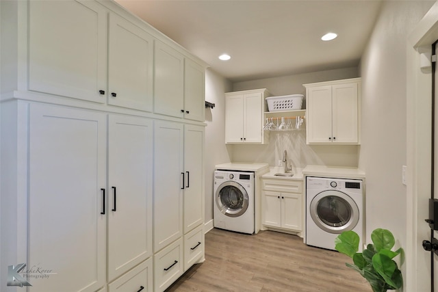 washroom with cabinet space, light wood finished floors, a sink, and recessed lighting