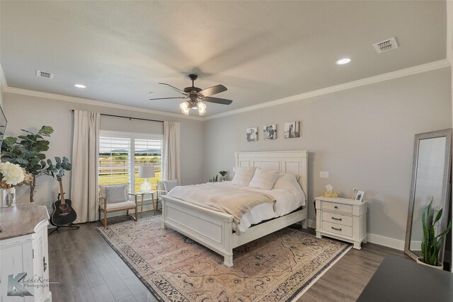 bedroom with ornamental molding, wood finished floors, visible vents, and baseboards