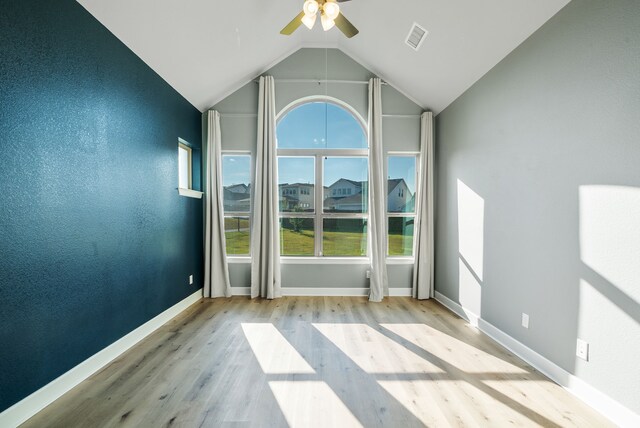 empty room featuring ceiling fan, high vaulted ceiling, and light hardwood / wood-style floors