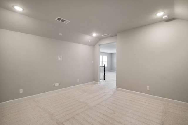 carpeted spare room featuring lofted ceiling