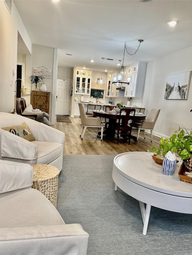 living room featuring a notable chandelier and light hardwood / wood-style floors