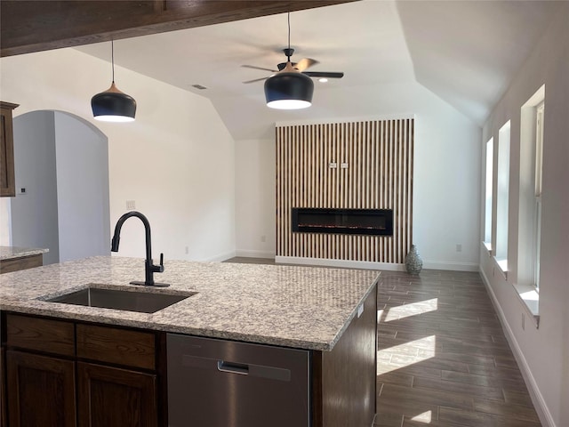 kitchen featuring ceiling fan, dishwasher, sink, light stone counters, and pendant lighting