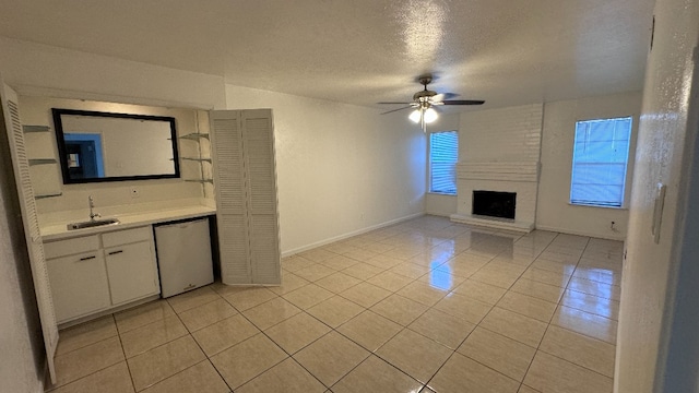 interior space with white cabinets, light tile patterned floors, white dishwasher, ceiling fan, and sink