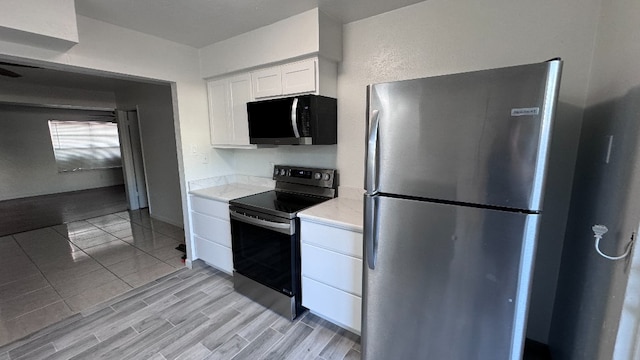 kitchen featuring white cabinets, light hardwood / wood-style floors, and appliances with stainless steel finishes