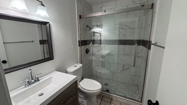 bathroom featuring tile patterned floors, walk in shower, vanity, and toilet