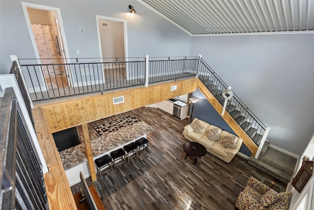 living room with a high ceiling, ornamental molding, and hardwood / wood-style flooring