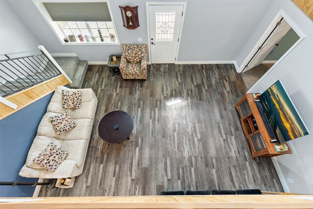 living room with stairs, baseboards, and wood finished floors