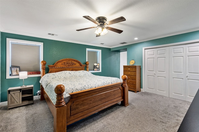 carpeted bedroom with a closet, ceiling fan, and ornamental molding