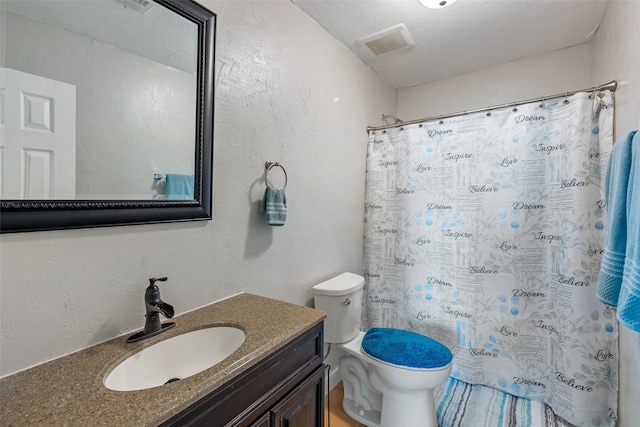 bathroom featuring toilet, vanity, and a shower with curtain