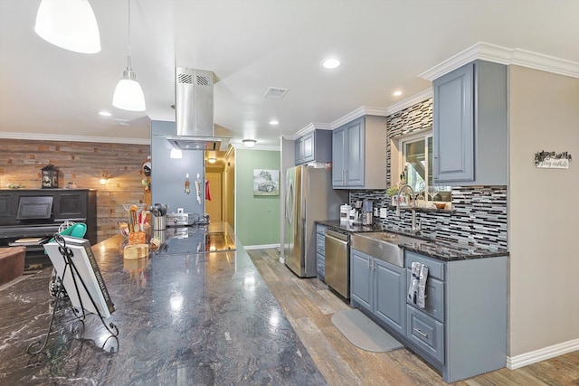 kitchen with light hardwood / wood-style flooring, tasteful backsplash, hanging light fixtures, blue cabinetry, and stainless steel appliances