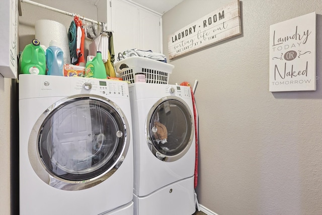 laundry area featuring washing machine and dryer and cabinets