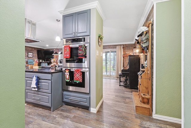 kitchen with decorative light fixtures, hardwood / wood-style flooring, ornamental molding, stainless steel double oven, and gray cabinets