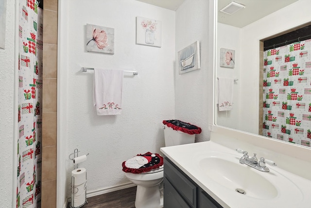 bathroom featuring toilet, vanity, wood-type flooring, and curtained shower