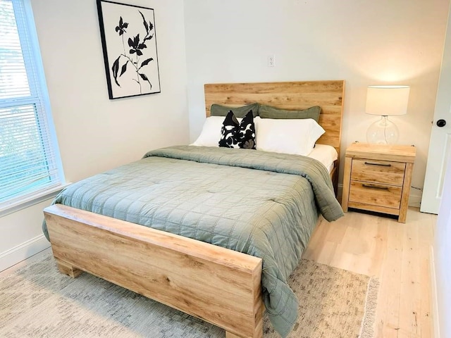 bedroom with hardwood / wood-style floors and multiple windows