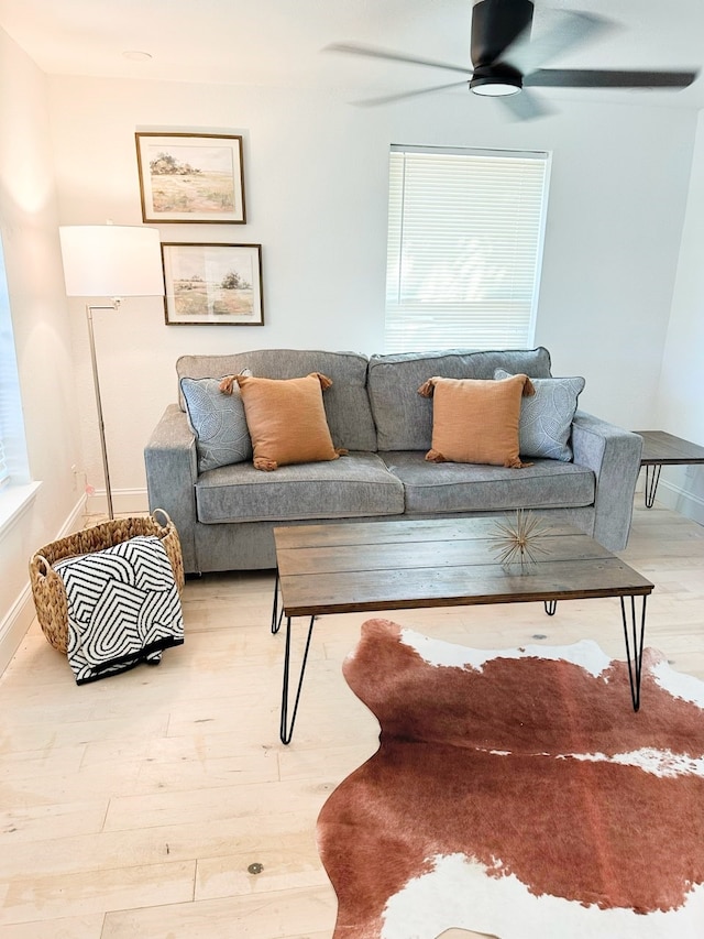 living room with plenty of natural light, wood-type flooring, and ceiling fan