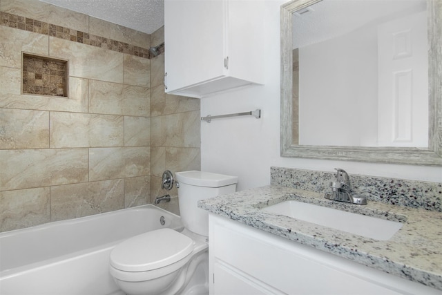 full bathroom featuring tiled shower / bath combo, toilet, a textured ceiling, and vanity